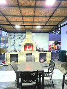 a table and chairs in a patio with a fireplace at Blue Horizon Apartments in Ureki