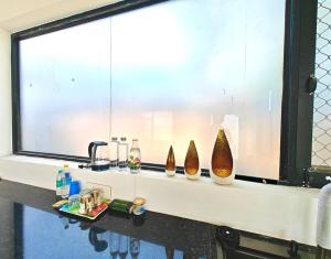 a counter with three vases sitting on a window sill at Oasis Murthal Open Field Views in Indraprast