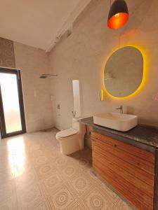 a bathroom with a sink and a toilet and a mirror at Oasis Murthal Open Field Views in Indraprast