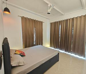 a bedroom with a bed and a window with curtains at Oasis Murthal Open Field Views in Indraprast
