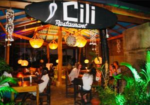 a group of people sitting at tables in a restaurant at Cili Hotel & Pizza Restaurant in Arugam Bay +23 photos