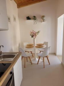 a kitchen with a table with chairs and a vase of flowers at Il Borghetto in Palinuro