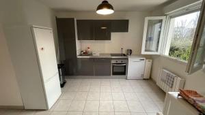 a kitchen with white appliances and a window at Le Pegan - Appartement 2 chambres proche du centre de Ferney et de Palexpo in Ferney-Voltaire