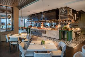 a restaurant with tables and chairs and a kitchen at Hyatt Regency Xi'An Chanba in Xi'an