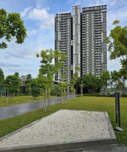 a park with trees in front of tall buildings at Sunset Retreat Sensory Residence in Kampung Dengkil