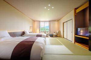 a hotel room with two beds and a flat screen tv at 六日町温泉 龍氣 in Minami Uonuma +68 photos