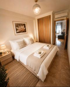 a bedroom with a large bed with two towels on it at Guesthouse Milagre Centro Faro in Faro