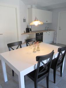 uma cozinha com uma mesa branca e cadeiras pretas em Vestervang Bed & Breakfast em Vildbjerg