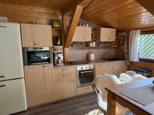 a kitchen with wooden cabinets and a white refrigerator at CHataBela in Svit