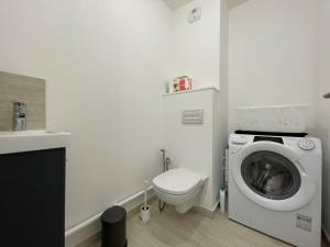 a white bathroom with a washing machine and a toilet at Apparté - Appartement proche Genève et Palexpo in Ferney-Voltaire