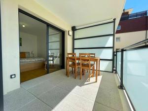 a dining room with a table and chairs and a bedroom at Apparté - Appartement proche Genève et Palexpo in Ferney-Voltaire