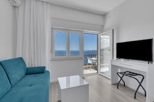 a living room with a blue couch and a television at Villa King Apartments in Brela