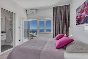 a bedroom with a large bed with purple pillows at Villa King Apartments in Brela