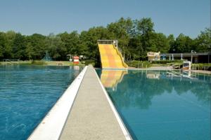 a swimming pool with a slide in the water at Ferienpark Grafschaft Bentheim in Uelsen