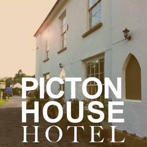 Un uomo in piedi fuori da una casa bianca di Picton-House a St Clears