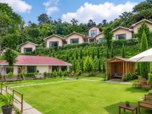 a house with a green yard with benches at Skywood by Vankuteer - Pool & Mountain view Rooms in Kandāghāt