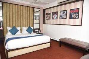 a bedroom with a bed and a bench in it at Belair Suites in Pune