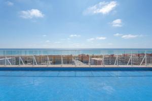 a swimming pool with the ocean in the background at Lopimar Bonito in Canet de Berenguer