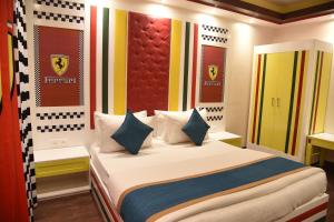 a bedroom with a bed with white sheets and blue pillows at Belair Suites in Pune