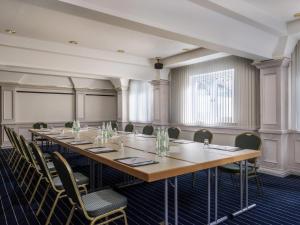 a conference room with a long table and chairs at Sunday Hotel Garmisch Partenkirchen in Garmisch-Partenkirchen