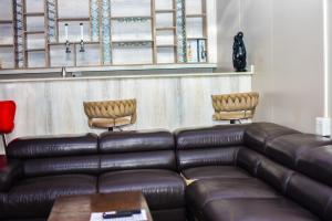 a leather couch in a room with two chairs at MKHUZE INN in Mkuze