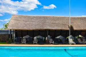 a large building with chairs and a swimming pool at MKHUZE INN in Mkuze
