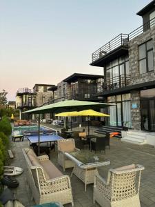 a patio with chairs and tables and an umbrella at Blue Horizon Apartments in Ureki