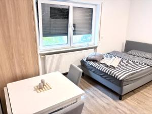 a small room with a bed and a table at Cozy Room Echterdingen Stuttgart Airport & Messe in Leinfelden-Echterdingen