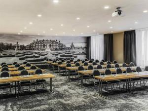 a classroom with desks and chairs in a room at Mercure Hotel Hamm in Hamm