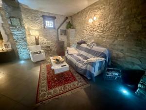 a living room with a bed and a stone wall at Casa San Francesco in Agnone
