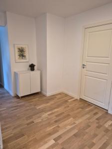 an empty room with a white door and wooden floors at Lägenhet i Sandhem in Sandhem