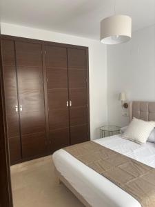 a bedroom with a bed and wooden cabinets at Fuente De La Salud in Priego de Córdoba