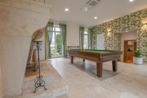 a room with a pool table and a fireplace at Le clos embelli in Rouvres-les-Vignes