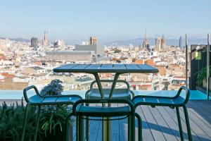 a table and chairs on a balcony with a view of a city at Andante Drassanes in Barcelona