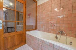 a bathroom with a tub and pink tiles at Le clos embelli in Rouvres-les-Vignes +27 photos