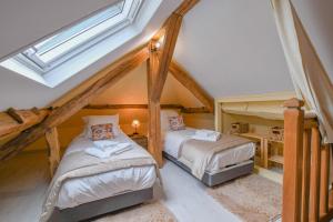 a attic bedroom with two beds and a skylight at Le clos embelli in Rouvres-les-Vignes