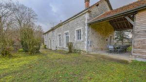 an old brick building with a picnic table on a yard at Le clos embelli in Rouvres-les-Vignes
