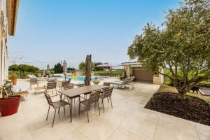 a patio with a table and chairs and a pool at La Maison Blanche in Saint-Sulpice-de-Faleyrens