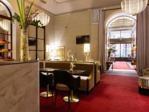 a lobby with a table and chairs in a room at Carlton Hotel Lyon - MGallery Collection in Lyon