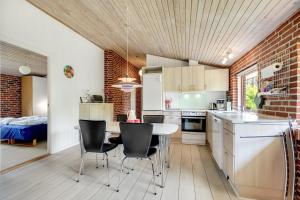 a kitchen with a table and chairs in a room at Skovvang 80 in Nørre Nebel