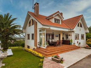 a house with a wooden deck in the yard at Villa Rubén in Miengo