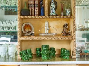 a shelf filled with green glass vases and a sink at Villa Rubén in Miengo