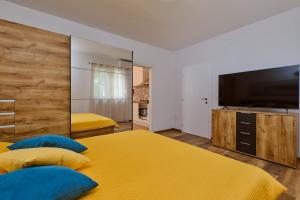a bedroom with two beds and a flat screen tv at Deja near centar and Čikat bay with private parking in Mali Lošinj
