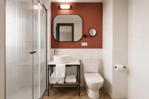 a bathroom with a toilet and a sink and a mirror at Honest Granada Hotel in Granada +56 photos