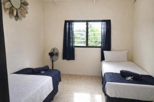 a bedroom with two beds and a window at Hidden Haven - Group Retreat-Sleeps 7 aircon & free Wifi in Rarotonga +35 photos