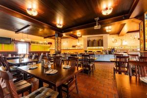 a restaurant with wooden tables and chairs and a kitchen at Hotel Purkmistr Beer & Spa Resort in Pilsen