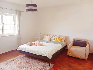 a bedroom with a bed and a chair at Great for Families in Lourinhã-Double Rooms-Private Baths-Free Parking & Extra Bed in Lourinhã +17 photos