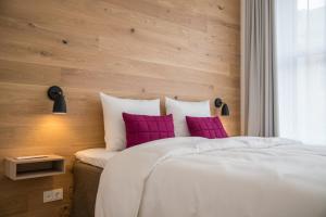 ein Schlafzimmer mit einem großen Bett mit lila Kissen in der Unterkunft Hotel Alte Post Flensburg in Flensburg + 35 Fotos