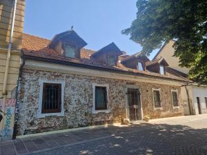 an old stone building with windows on a street at Rooms Sincere 1830 in Ljubljana
