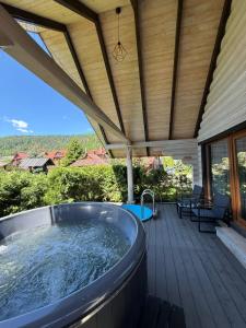 a hot tub on the deck of a house at Verdant House in Mykulychyn